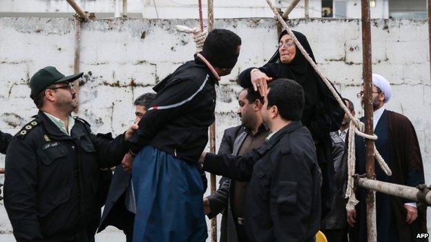 The mother (R) of Abdollah Hosseinzadeh slaps the face of Balal, who killed her son, on 15 April 2014