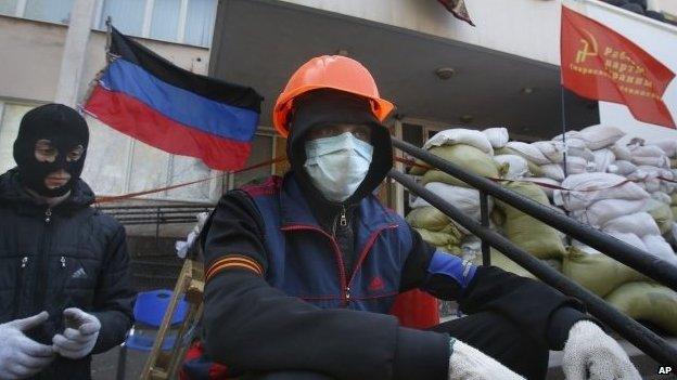 Masked pro-Russian protesters guard a barricade in front of the city hall in Mariupol, eastern Ukraine, Thursday, April 17, 2014