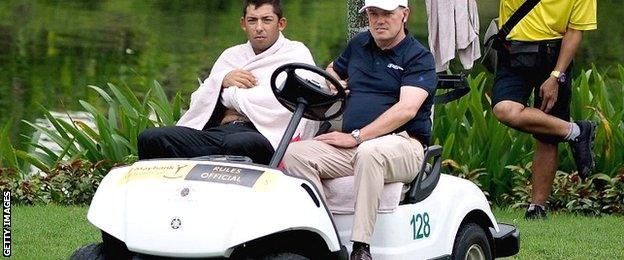 Pablo Larrazabal (left) is driven away from the lake by a Tour official