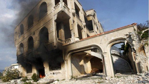 Fire burns in a damaged building in Homs (21 March 2014)