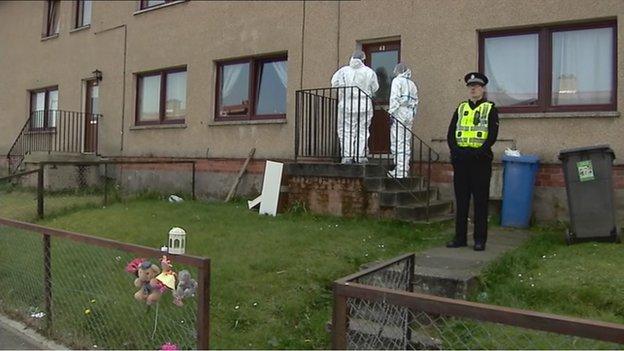 forensic officers and a police officer at the house