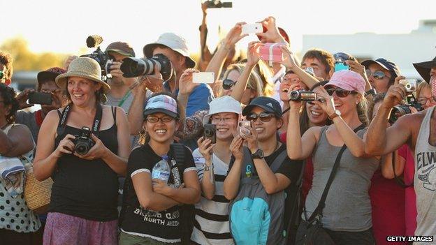 Well-wishers take photos of the royal couple