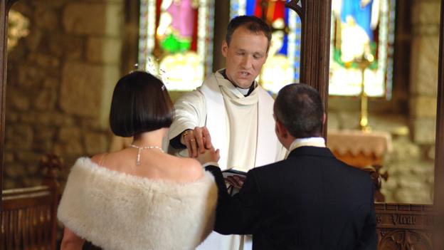 Vicar officiates at church wedding