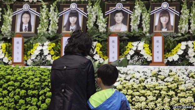 A woman and child pay tribute at a memorial to victims of the sunken ferry at the Ansan Olympic Memorial Hall - 23 April 2014