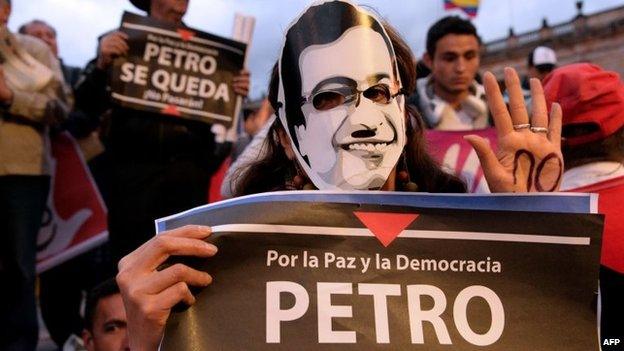 A supporter of dismissed Bogota Mayor Gustavo Petro holds a sign reading "For Peace and Democracy, Petro" during a demonstration in downtown Bogota after Colombian President Juan Manuel Santos announced his dismissal on 19 March, 2014