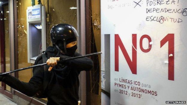 A protestor attacks a bank in last month's demonstrations