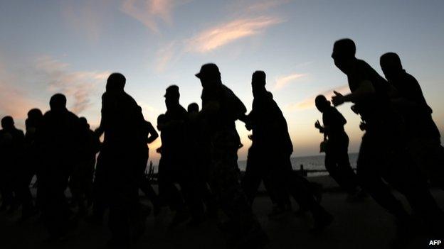 Hooded Palestinian Hamas militants exercise as the sun sets in Gaza City on April 23, 2014