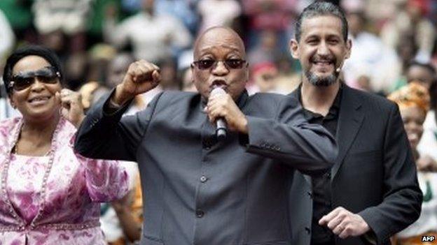 South African President Jacob Zuma (2nd L) sings and dances on the stage at the Ellis Park stadium in Johannesburg as he stands next to Bishop Marcelo Pires (2nd R) attending a Good Friday service with the Universal Church of the Kingdom of God on 18 April 2014