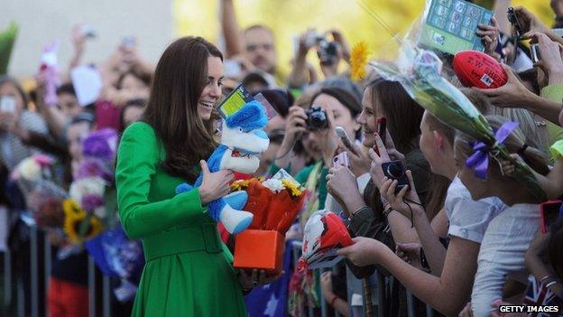 Catherine receives presents as she greets the public after visiting the National Portrait Gallery in Canberra