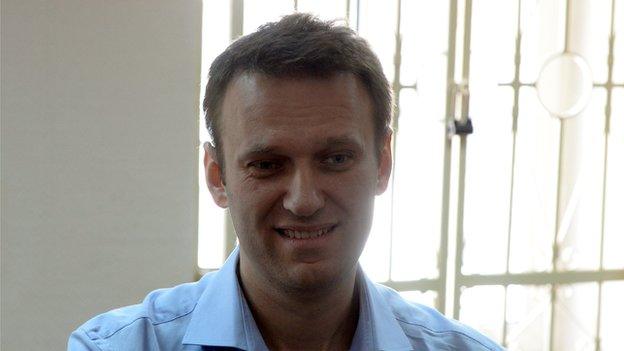 Kremlin critic and opposition leader Alexei Navalny smiles as he stands in a courtroom in Moscow, on 24 April 2014.