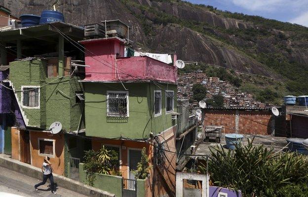 Woman walks down a street in a housing complex at the Rocinha slum in Rio de Janeiro