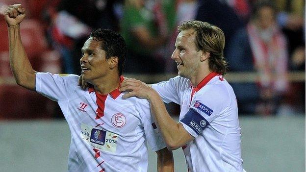 Carlos Bacca and Ivan Rakitic celebrate