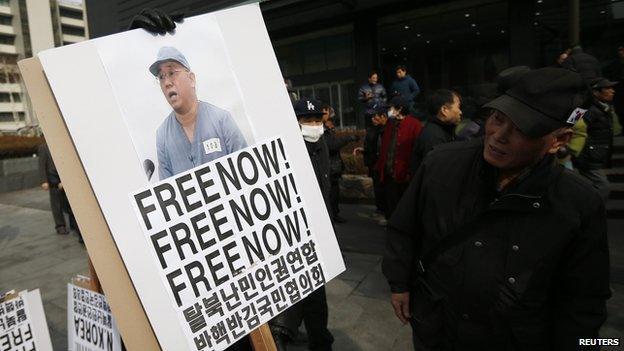 Anti-North Korean protesters hold a sign showing US Christian missionary Kenneth Bae in central Seoul on 16 February 2014.