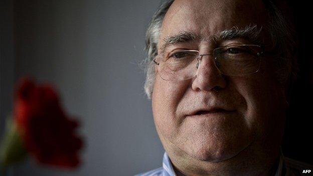 Vasco Lourenco looks at a red carnation, symbol of Portugal's Carnations Revolution, in Lisbon on 17 April 2014.