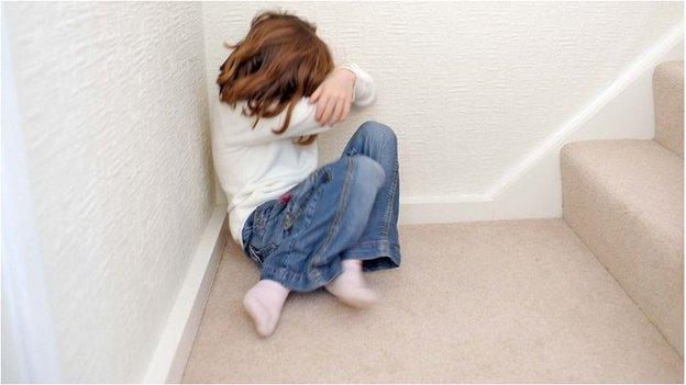 Young girl on stairs hiding her face