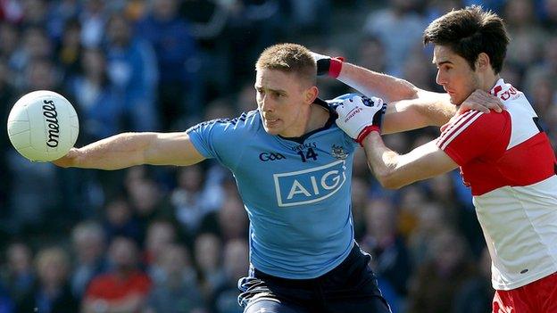 Eoghan O'Gara holds off Chrissy McKaigue after winning the ball at Croke Park