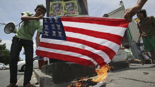 Filipino activists burn a mock US flag as they hold a short protest in Manila, Philippines on Sunday 27 April 2014