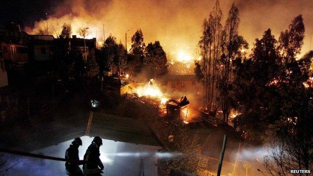 Firefighters work to put out a fire in Valparaiso city, northwest of Santiago on 13 April, 2014