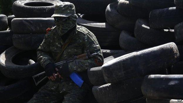 A pro-Russian armed man sits in front of the city hall in Kostyantynivka