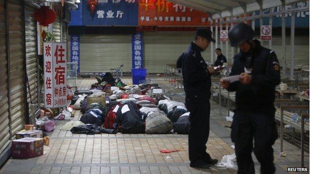 Policemen check unclaimed luggage at a square outside the Kunming railway station after a knife attack, in Kunming, Yunnan province, 2 March 2014