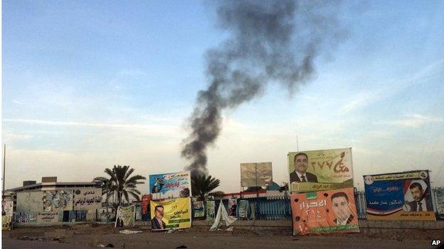 Smoke rises above election campaign posters after bomb attack in Baghdad (25/04/14)