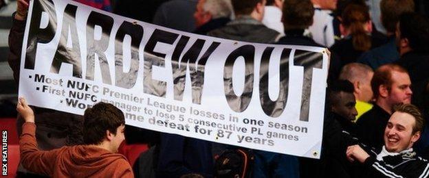 Newcastle fans hold up a 'Pardew Out' banner at the Emirates Stadium