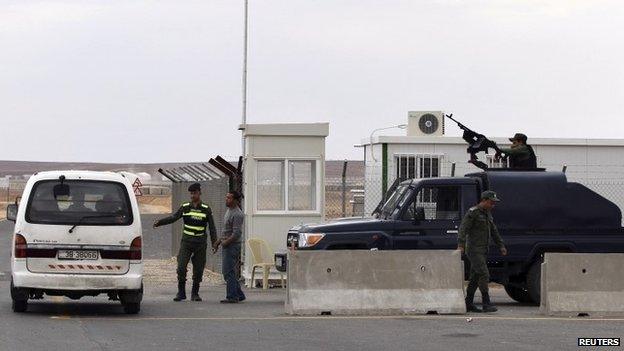 Police officers stand guard at the entrance to Azraq camp