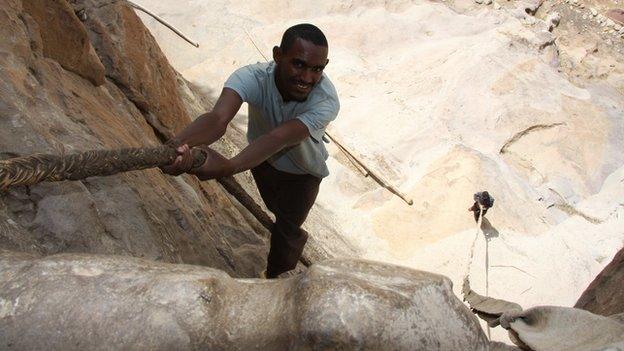 A young Ethiopian man ascends a 15m-high rock face with the aid of a leather rope to reach the cliff top monastery of Debre Damo, dating from the 6th century, in northern Ethiopia