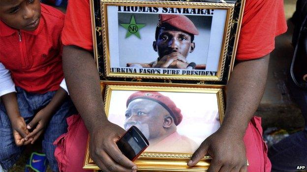 An EFF supporter holds portraits of former president of Burkina Faso Thomas Sankara and populist South African leader Julius Malema as he attends the launch of the EFF's manifesto in Thembisa on 22 February 2014