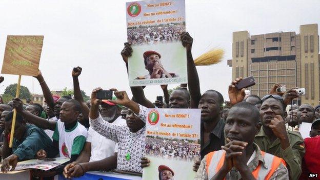 A man holds a placard reading "No to the Senate, No to the referendum, No to the revision of article 37" as he joins a protest in Ouagadougou on 18 January 2014 against a modification of Burkina Faso's constitution which would allow the country's President Blaise Compaore to present himself in 2015 for a third five year mandate