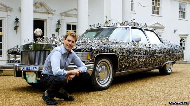 Geller next to a car covered in spoons