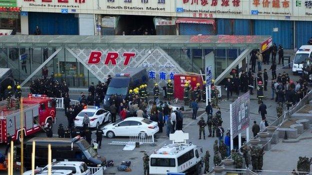 Security personnel gather near the scene of an explosion outside the Urumqi South Railway Station in Urumqi in northwest China's Xinjiang Uighur Autonomous Region on 30 April 2014