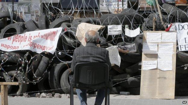 A pro-Russian activist sitting at a barricade at the regional administration building in Donetsk, Ukraine, 29 April 2014