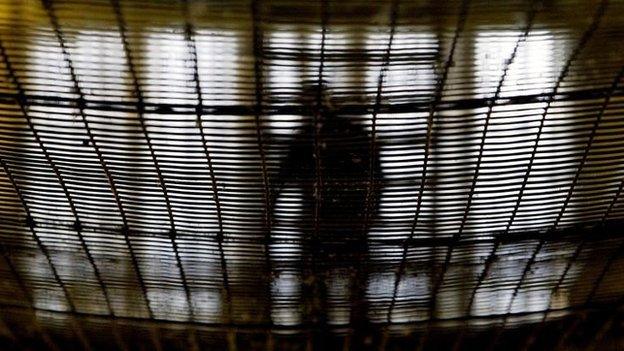 A prisoner at HMP Pentonville walks through an atrium May 19, 2003 in London.