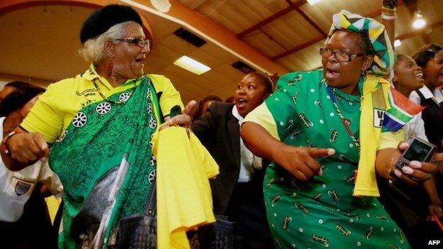 Supporters of the ruling South African political party the African National Congress (ANC) dance and sing before the arrival of the South African president during a campaign event at the Inter-fellowship Church in Wentworth township, outside of Durban, on 9 April 2014