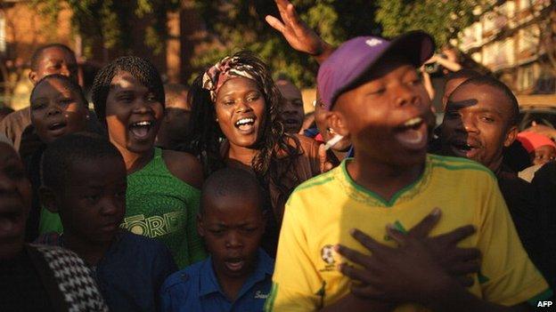 A large crowd of supporters sings the South African national anthem outside a hospital where former South African President Nelson Mandela was being treated in June 2013 in Pretoria, South Africa