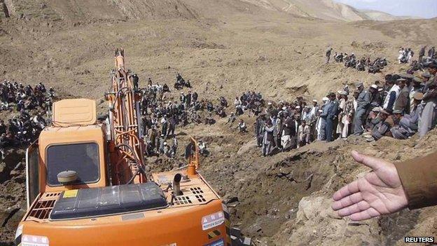 An excavator digs at the site of a landslide at the Hargu district in Badakhshan province, 3 May 2014