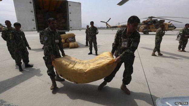 Afghan National Army troops load supply for survivors of the Badakhshan landslide onto a helicopter in Kabul, 3 May 2014