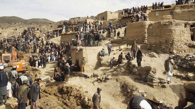 Afghan villagers gather at the site of a landslide at the Argo district in Badakhshan province,