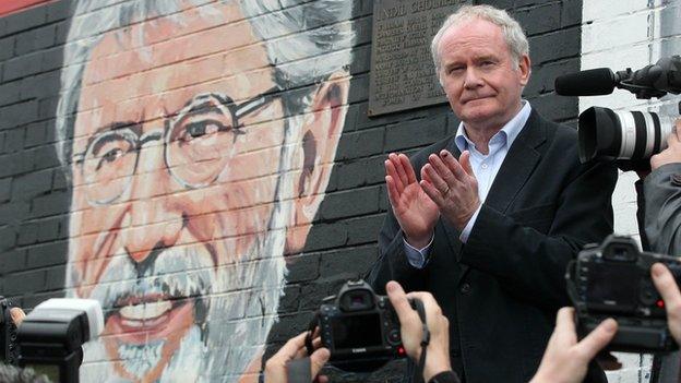 Martin McGuinness applauds after speaking at a rally