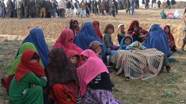 Landslide-affected Afghan villagers look on as they await donated relief supplies at the scene of the incident in Argo district in Badakhshan on May 4, 2014