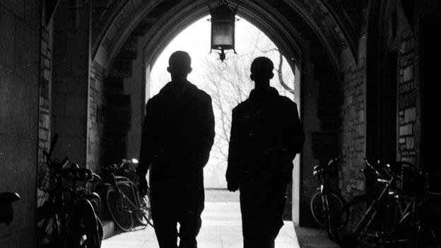 Two men walk through a tunnel on the Princeton University campus.