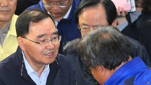 South Korean Prime Minister Chung Hong-won, left, consoles a relative of a passenger aboard the sunken Sewol ferry at a gymnasium in Jindo, South Korea, Thursday, May 1, 2014