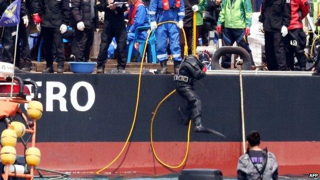 A diver jumps into the sea to search missing passengers at the site of the sunken South Korean ferry "Sewol" off Jindo on April 25, 2014.