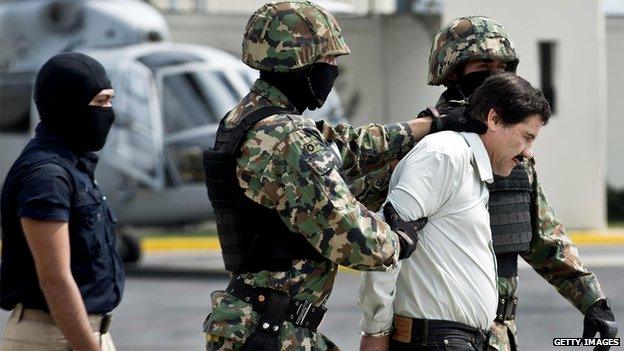 Mexican drug trafficker Joaquin Guzman is escorted by marines as he is presented to the press on 22 February, 2014