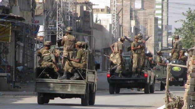 Pakistan Army troops prepare to leave for patrolling during a curfew in Bannu, a town on the edge of Pakistan"s lawless tribal belt Waziristan, Saturday, Oct. 17, 2009.