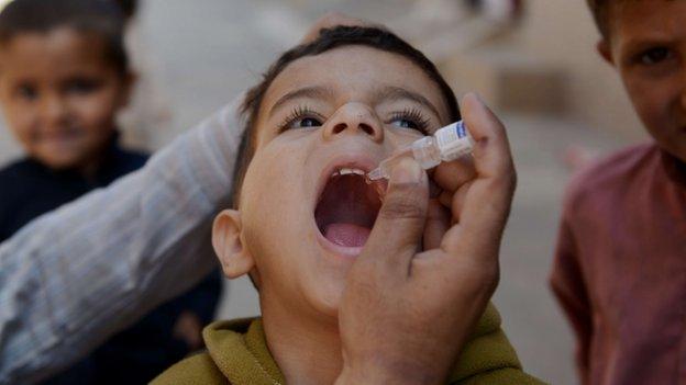 Pakistani child receives polio vaccination drops from health worker in Rawalpindi on 8 April 2014.