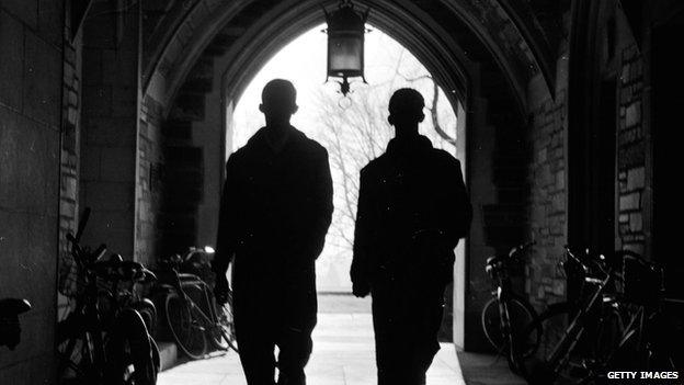 Two men walk through a tunnel on the Princeton University campus.