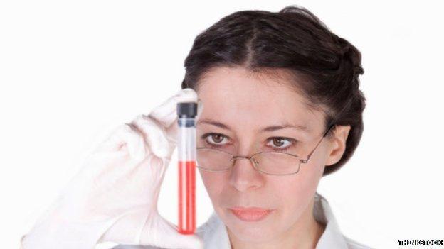 Scientist looking at test tube