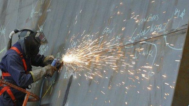 A ship builder works on a section of the first of two Queen Elizabeth class aircraft carriers at BAE Systems in Portsmouth. 08/12/2010